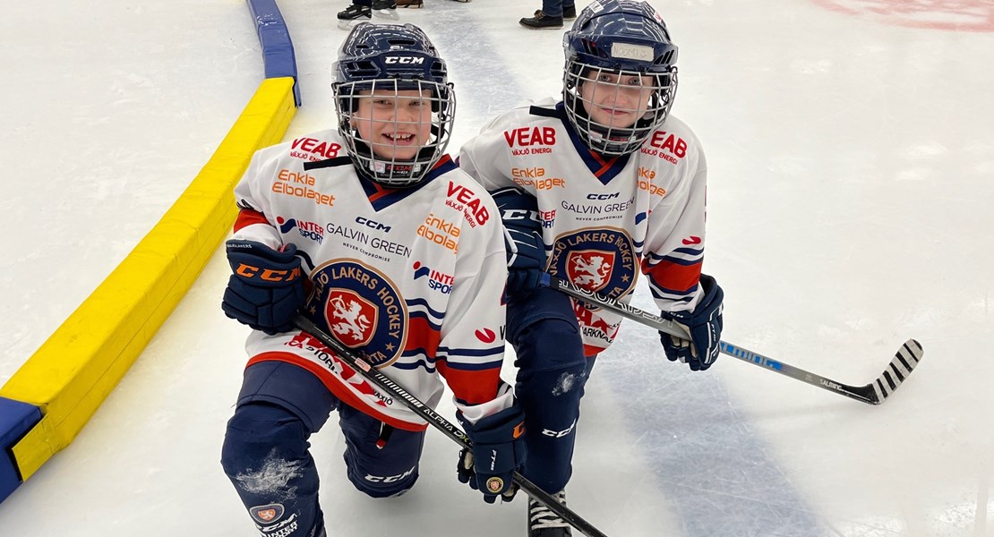 Hockeytjejer sittande på knä  på isen i hockeyarenan.