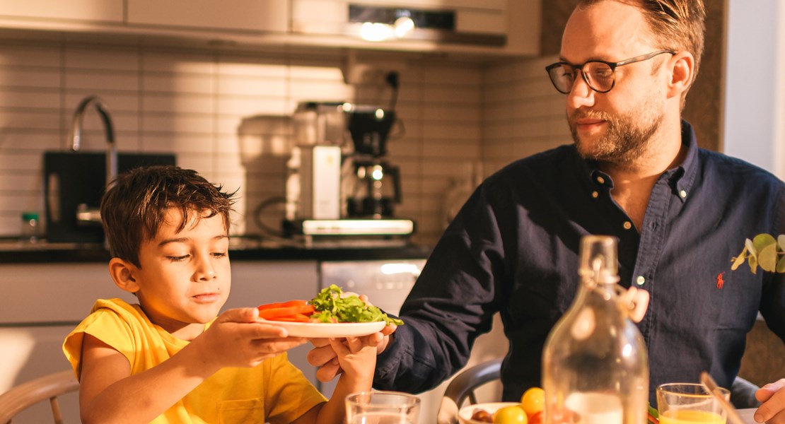 Familj som sitter vid frukostbordet